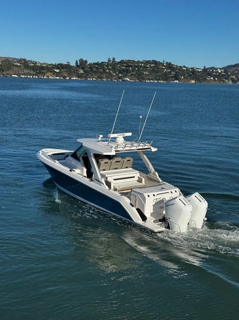 Slide: The Image of A 2024 Tiara Yachts 34 LS cruising on calm water with two outboard engines. - 8