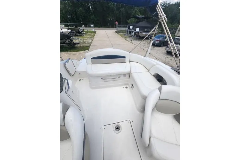 Slide: The Image of 2008 Chaparral Sunesta 224 boat interior with white seating and blue canopy. - 7