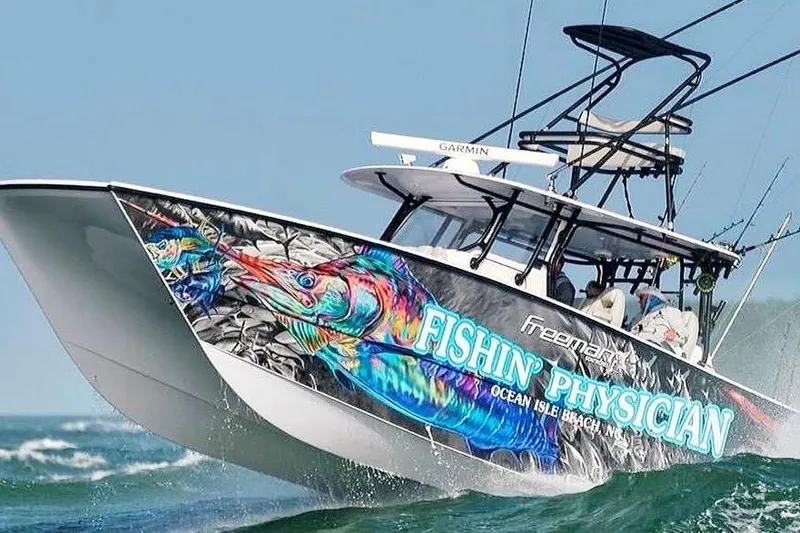 Slide: The Image of 2020 Freeman 42LR boat with vibrant fish artwork, named "Fishin' Physician," on ocean waves. - 5