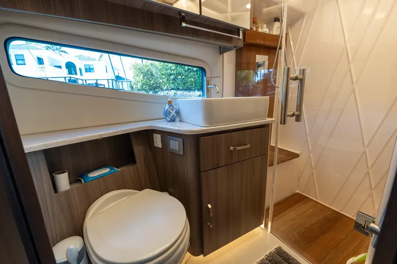 Slide: The Image of Modern bathroom in 2022 Regal 42 XO yacht with sleek fixtures and wood accents. - 52