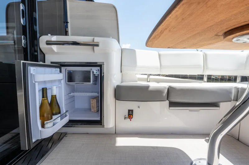 Slide: The Image of Luxury yacht interior with open mini-fridge, wine bottles, and seating on Regal 42 XO, 2022 model. - 25