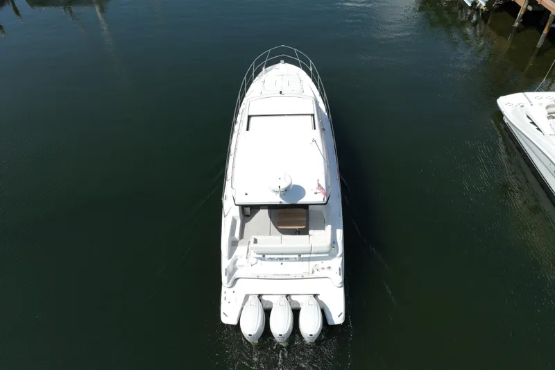 Slide: The Image of Aerial view of 2022 Regal 42 XO yacht with triple outboard engines on water. - 14