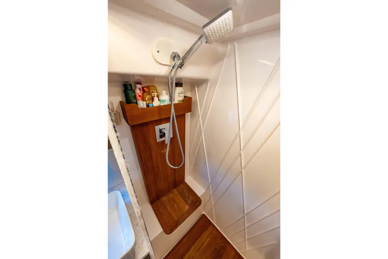 Slide: The Image of Shower area in 2022 Regal 42 XO yacht with wooden accents and toiletries. - 55