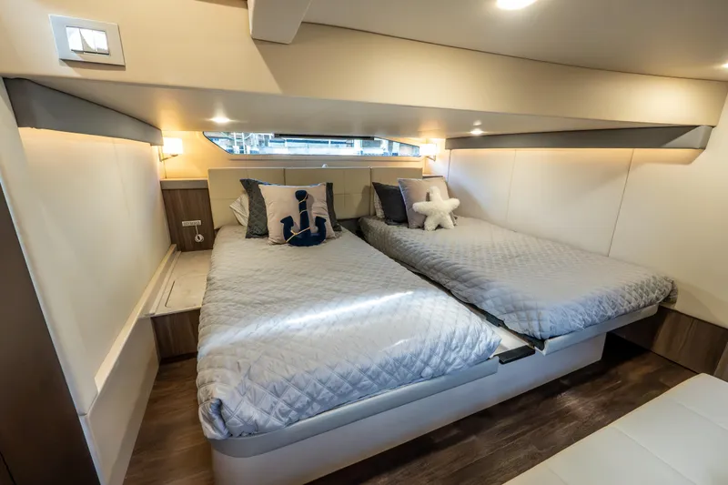 Slide: The Image of Luxurious 2022 Regal 42 XO yacht cabin with twin beds and nautical decor. - 58