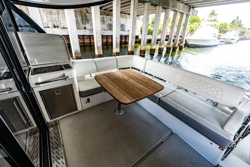 Slide: The Image of Luxurious 2022 Regal 42 XO yacht interior with seating and dining area under a bridge. - 24