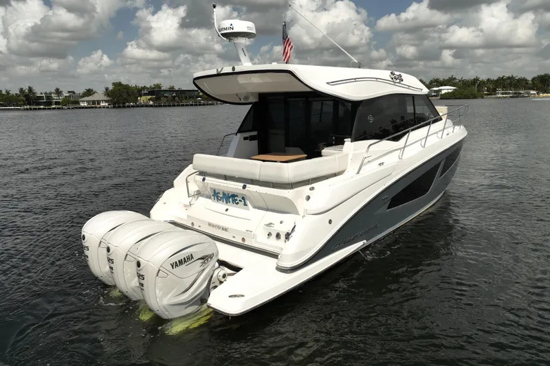 Slide: The Image of 2022 Regal 42 XO yacht with triple Yamaha engines on a calm waterway. - 3