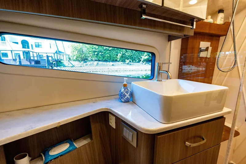 Slide: The Image of Luxurious bathroom interior of 2022 Regal 42 XO yacht with modern sink and window view. - 53