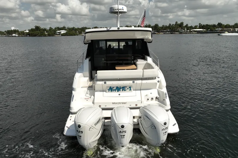 Slide: The Image of 2022 Regal 42 XO yacht with triple Yamaha 425 V8 engines on a calm waterway. - 4