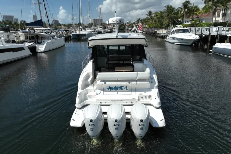 Slide: The Image of 2022 Regal 42 XO yacht with triple outboard engines docked in a marina. - 13