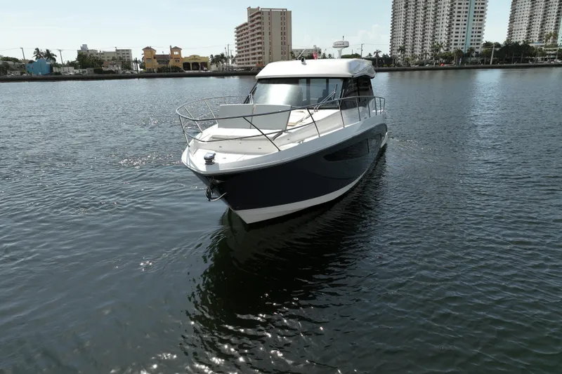 Slide: The Image of 2022 Regal 42 XO yacht cruising on a calm urban waterway. - 15