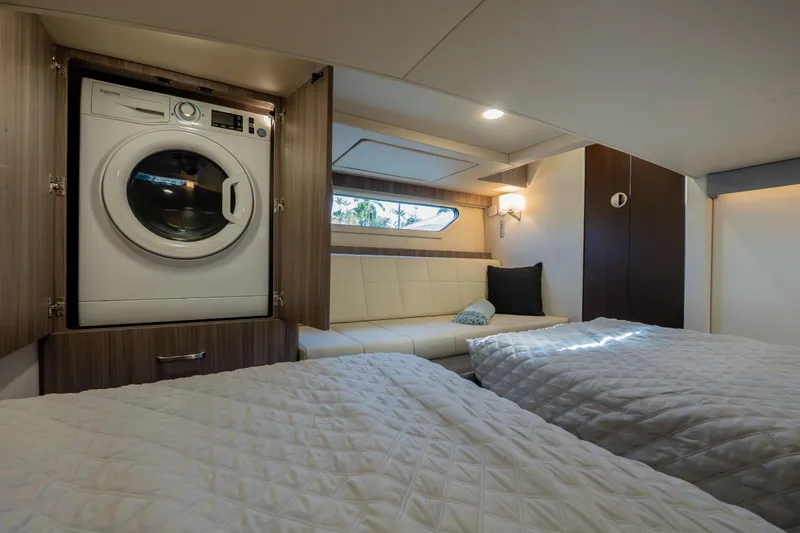 Slide: The Image of Luxurious 2022 Regal 42 XO yacht cabin with washer, beds, and seating area. - 60