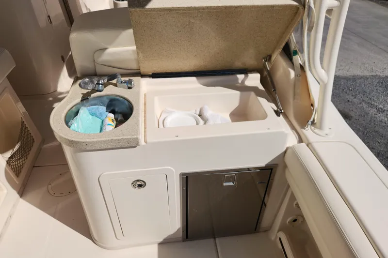 Slide: The Image of 2015 Grady-White Freedom 307 boat interior with sink and storage compartments. - 14