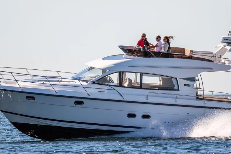 The Image of 2017 Nimbus 405 Flybridge yacht cruising on open water with passengers on deck. - 0