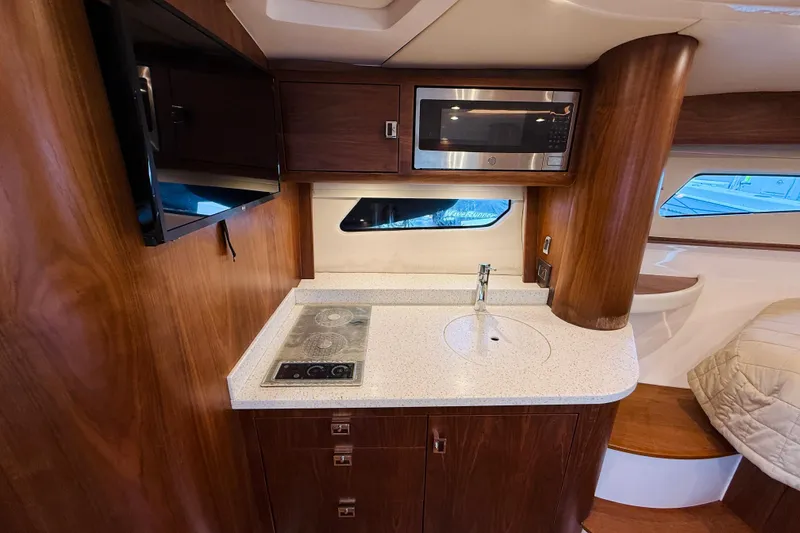 Slide: The Image of Luxurious 2021 Intrepid 410 Evolution yacht interior with modern kitchenette and wood finish. - 44