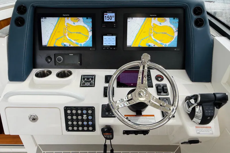 Slide: The Image of Control panel of 2021 Intrepid 410 Evolution boat with navigation screens and steering wheel. - 30