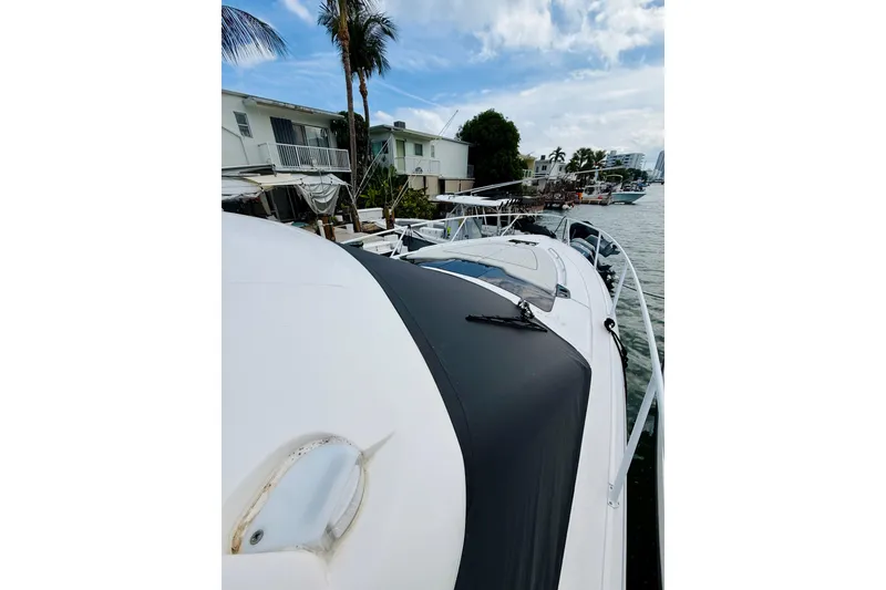 Slide: The Image of 2021 Intrepid 410 Evolution yacht docked by waterfront homes. - 7