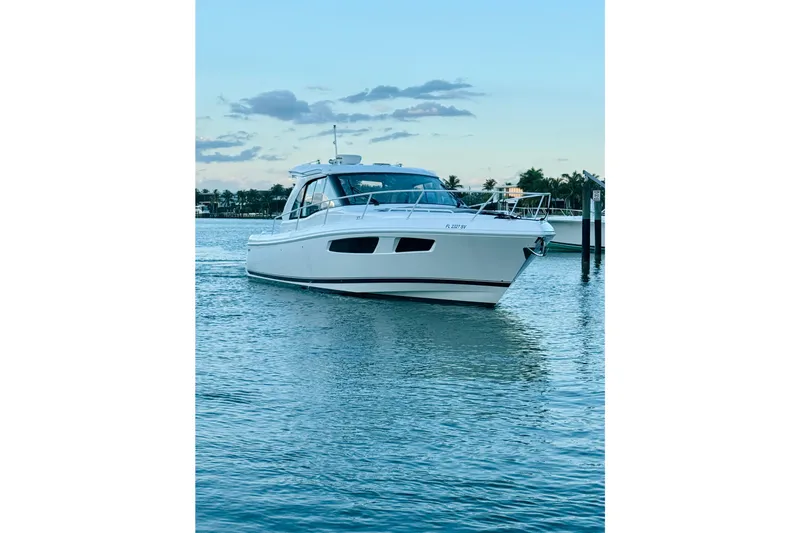 The Image of 2021 Intrepid 410 Evolution yacht on calm water at sunset. - 0