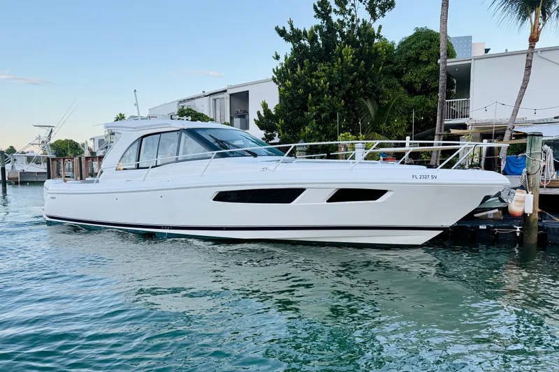Slide: The Image of 2021 Intrepid 410 Evolution yacht docked in a serene marina setting. - 1