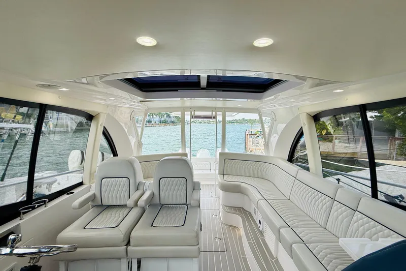 Slide: The Image of Luxurious interior of 2021 Intrepid 410 Evolution yacht with plush seating and panoramic windows. - 24