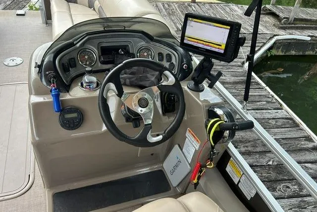Slide: The Image of 2020 Sun Tracker SportFish 22 XP3 boat dashboard with steering wheel and Garmin navigation system. - 2