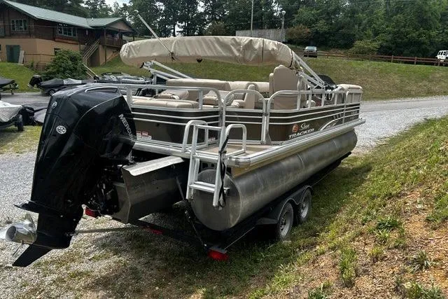 Slide: The Image of 2020 Sun Tracker SportFish 22 XP3 pontoon boat on a trailer, parked outdoors. - 14