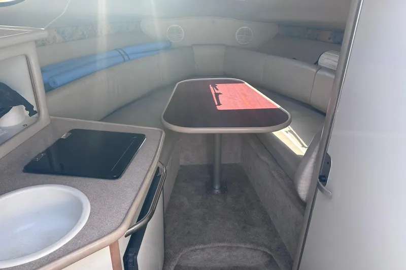 Slide: The Image of 1999 Chaparral Signature 240 cabin interior with table and kitchenette. - 11