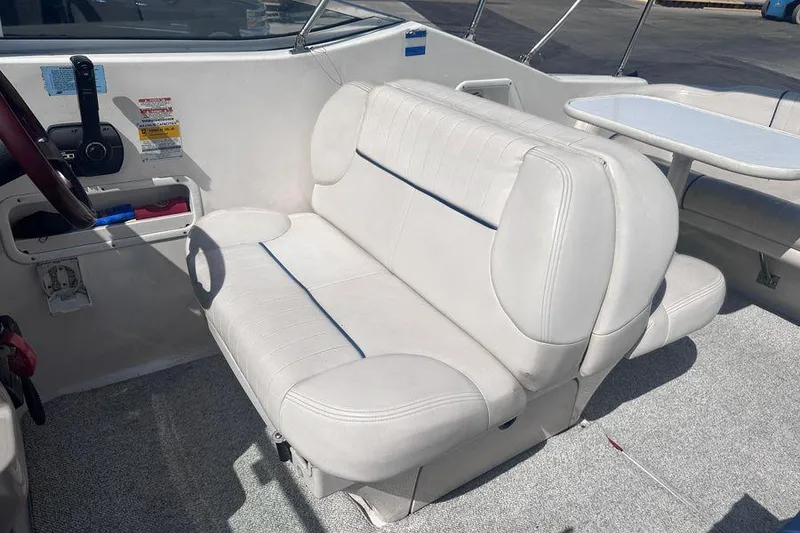 Slide: The Image of 1999 Chaparral Signature 240 boat interior with white seating and steering wheel. - 7