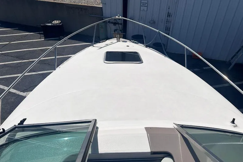Slide: The Image of 1999 Chaparral Signature 240 boat deck view, parked in a lot near a building. - 6