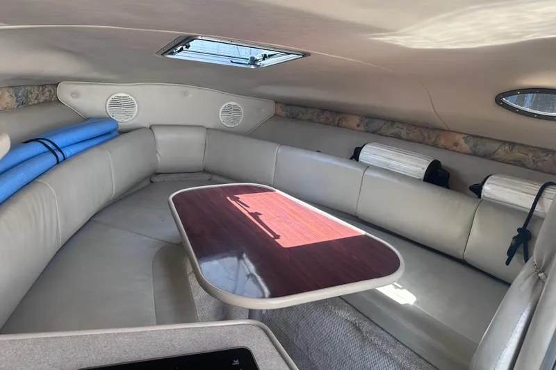Slide: The Image of 1999 Chaparral Signature 240 cabin interior with seating and table, featuring a skylight. - 12