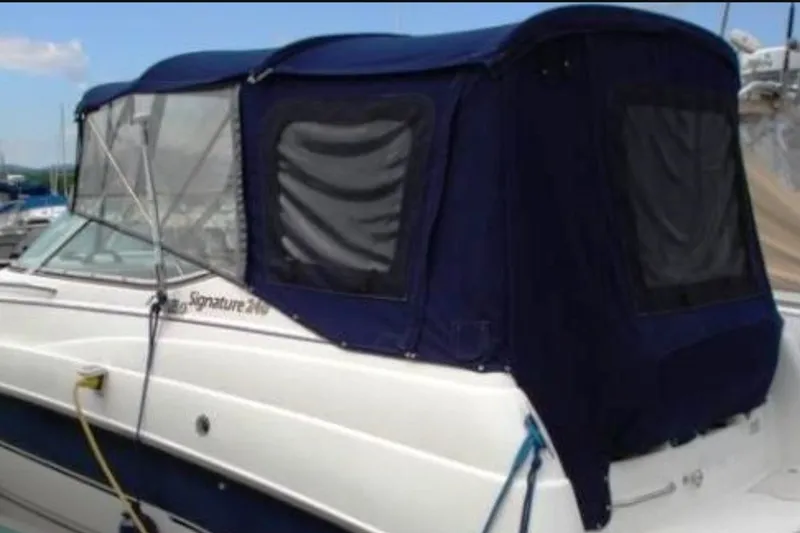 Slide: The Image of 1999 Chaparral Signature 240 boat with blue canvas cover docked at marina. - 24