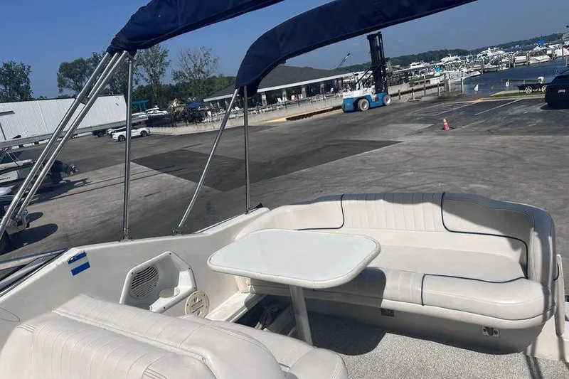 Slide: The Image of 1999 Chaparral Signature 240 boat interior with seating and table at a marina. - 8