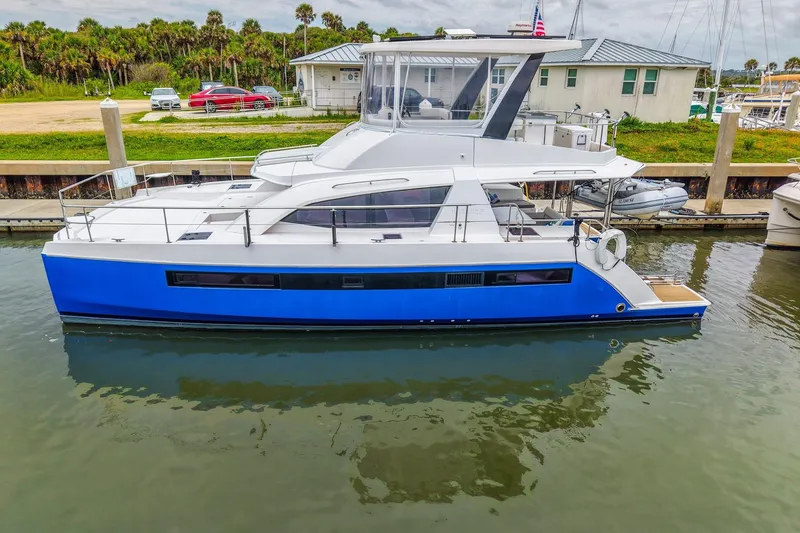 Slide: The Image of 2021 Leopard 43 Powercat yacht docked, featuring sleek design and vibrant blue hull. - 1