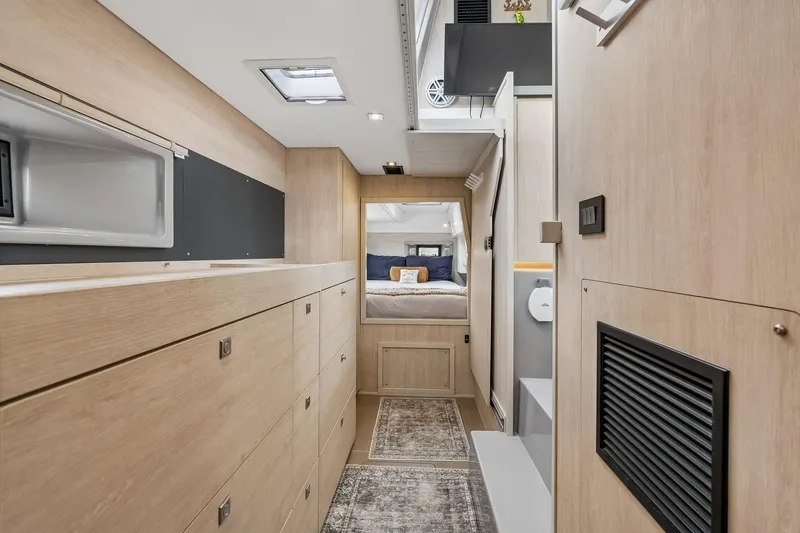 Slide: The Image of Interior of 2021 Leopard 43 Powercat, featuring modern wood cabinetry and cozy sleeping area. - 35