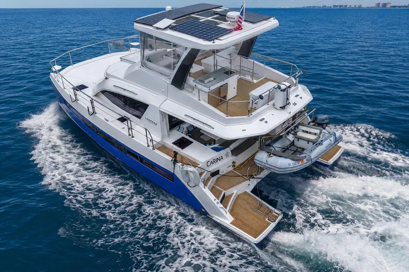 The Image of 2021 Leopard 43 Powercat cruising on open sea with solar panels and dinghy. - 0