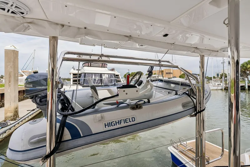 Slide: The Image of Highfield dinghy on Leopard 43 Powercat 2021, docked at marina with Yamaha outboard motor. - 43