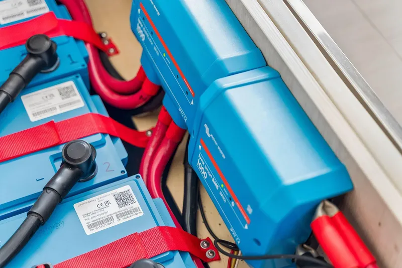 Slide: The Image of Battery system in a 2021 Leopard 43 Powercat, featuring blue lithium batteries and red cables. - 58