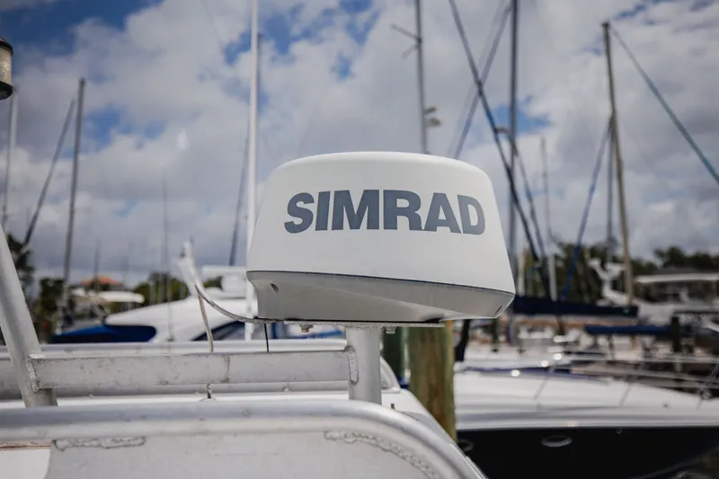 Slide: The Image of Simrad radar on a boat in a marina, surrounded by other boats and masts. - 11