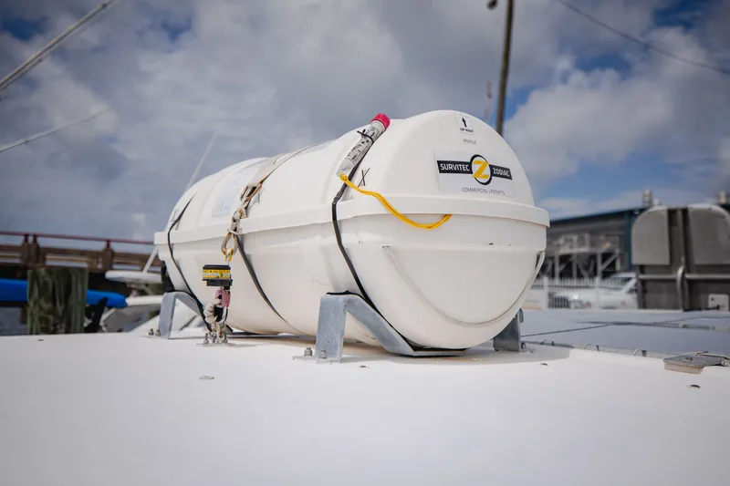 Slide: The Image of A liferaft is secured on a boat's deck, surrounded by a marina. - 12