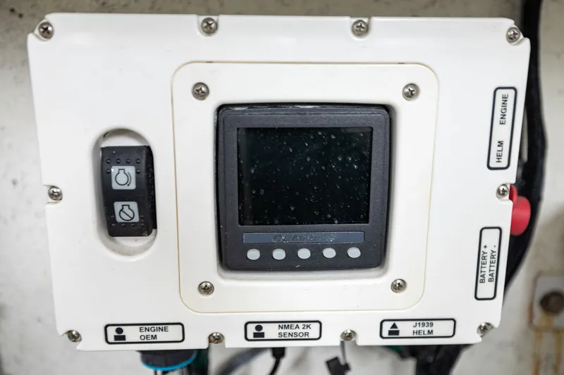 Slide: The Image of A control panel with a screen and switches, surrounded by cables, inside a boat. - 37
