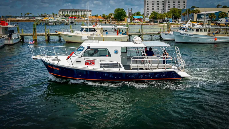 Slide: The Image of A 2019 Newton 36' Dive Special boat cruising in a harbor. It features a covered deck. - 8