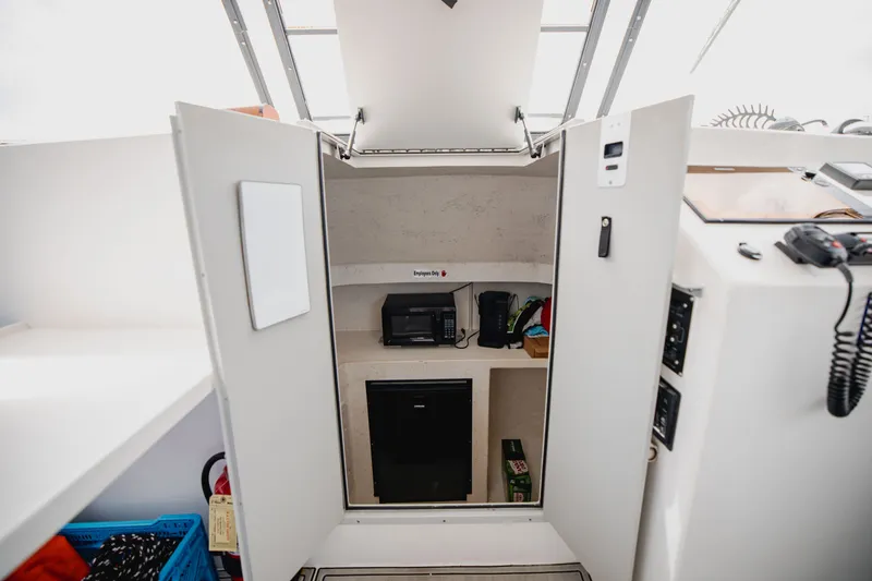 Slide: The Image of Interior of a boat with storage, a refrigerator, and appliances. - 16