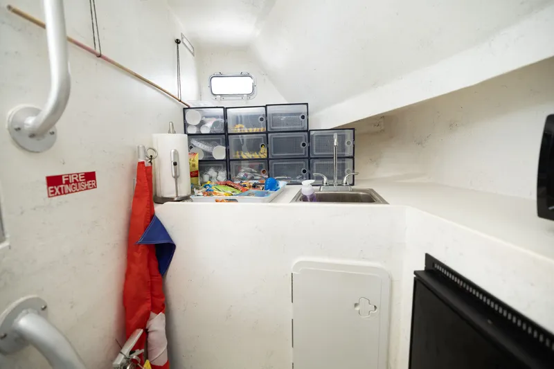 Slide: The Image of Interior of a boat with a sink, storage bins, and a fire extinguisher. - 18