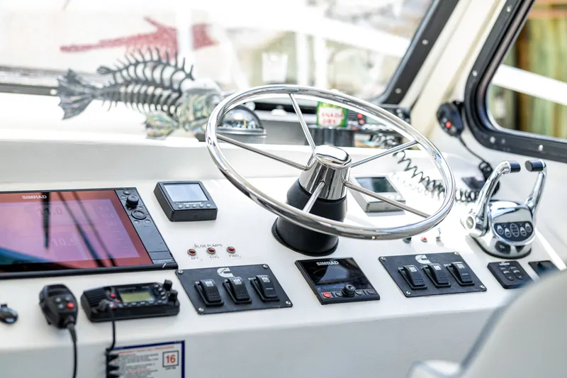 Slide: The Image of The image shows a boat's helm with a large steering wheel and various instruments. - 26