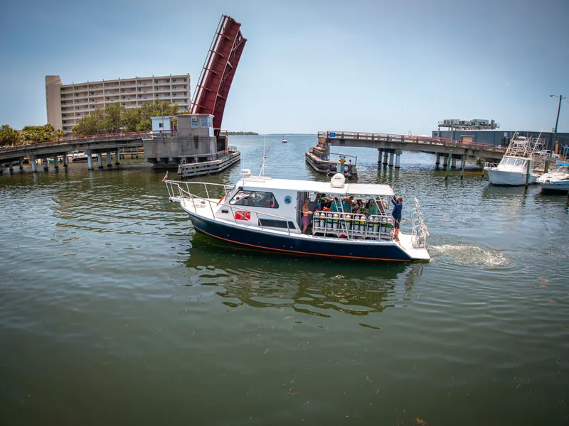 Slide: The Image of A 2019 Newton 36' Dive Special boat passes under an open bridge. - 1