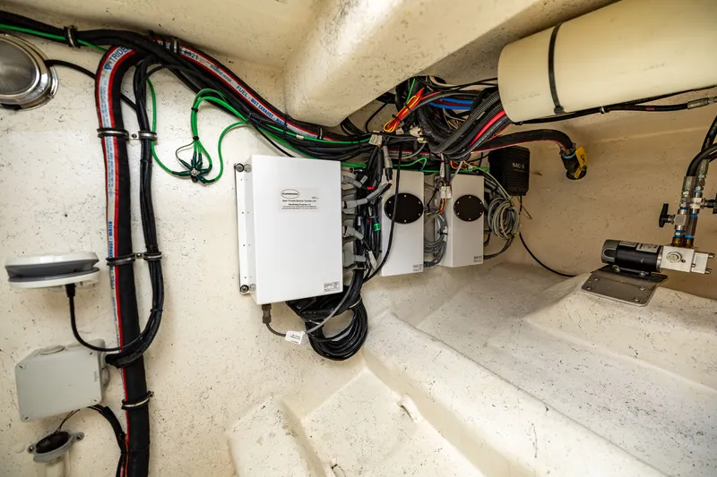 Slide: The Image of Electrical wiring and equipment inside a boat, featuring various cables and control boxes. - 38
