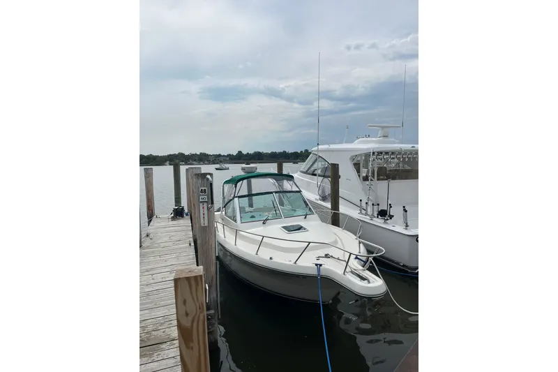 Slide: The Image of 2000 Pursuit 2860 Denali boat docked at marina, calm waters, overcast sky. - 2