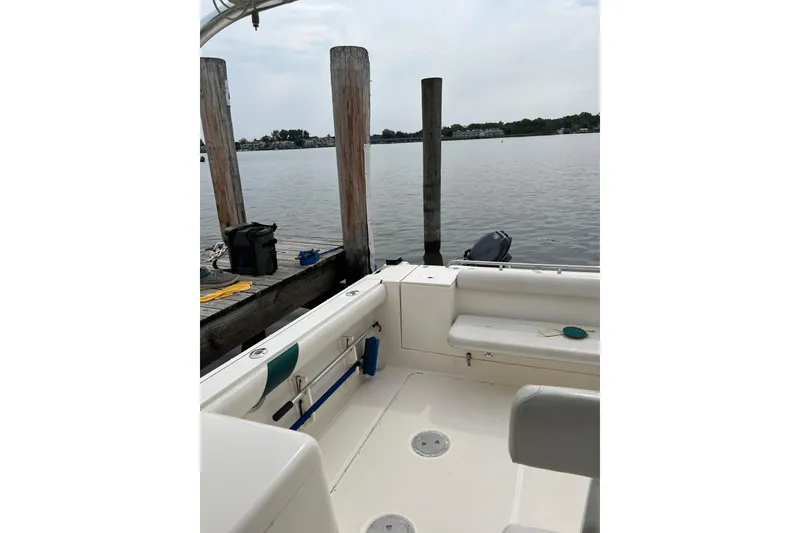 Slide: The Image of 2000 Pursuit 2860 Denali boat docked by a calm waterfront. - 15