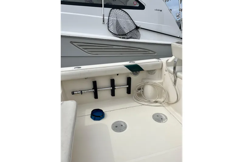 Slide: The Image of 2000 Pursuit 2860 Denali boat deck with fishing rod holders and coiled rope. - 16