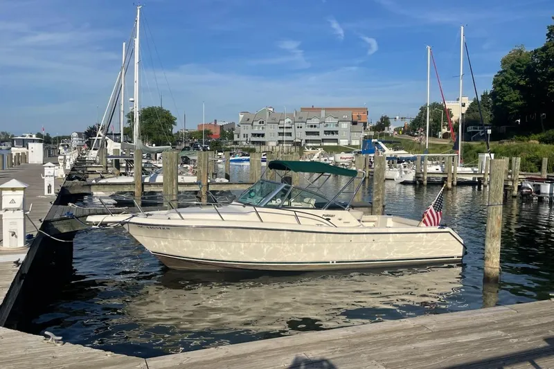 Slide: The Image of 2000 Pursuit 2860 Denali boat docked at a marina with clear skies. - 1
