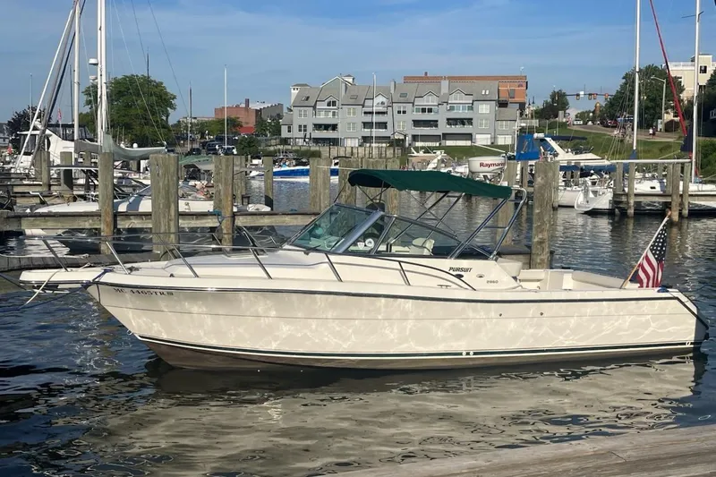 The Image of 2000 Pursuit 2860 Denali boat docked at a marina with American flag. - 0